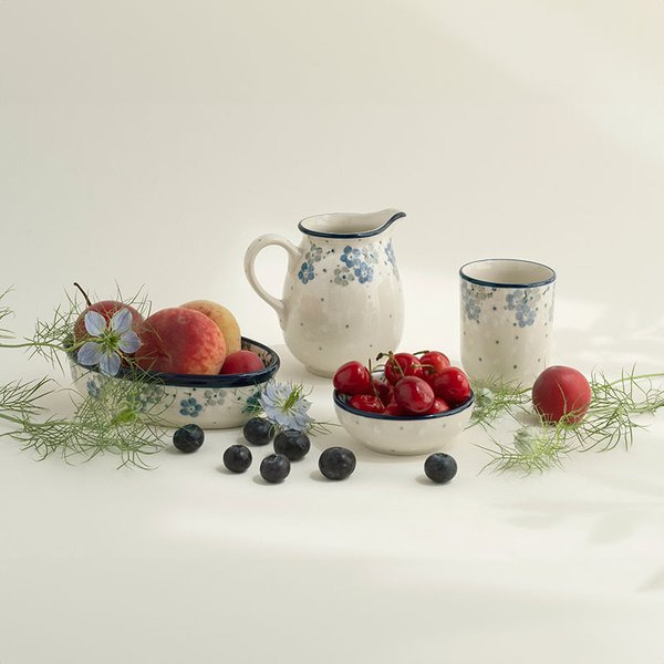 Tischgarnitur mit Bunzlauer Keramik, Früchten und grünen Pflanzen